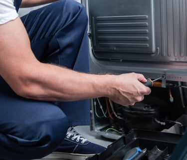 a man in a white shirt is fixing a machine