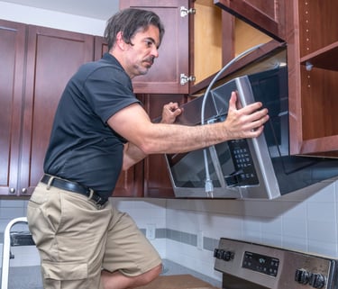 a man is standing in front of a microwave