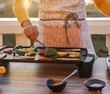 a woman in a white apron is cooking on a grill