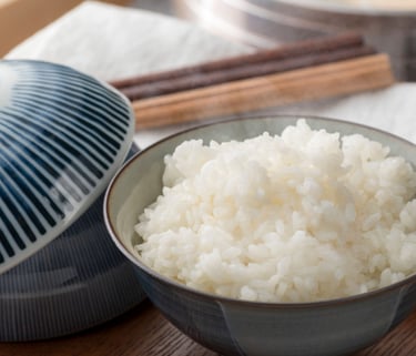 a bowl of rice with chopsticks and chopsticks