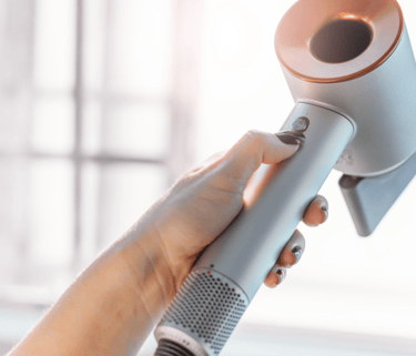 a woman is holding a hair dryer in her hand
