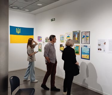 Visitors at the Spanish art gallery with paintings made by kids affected by the war in Ukraine