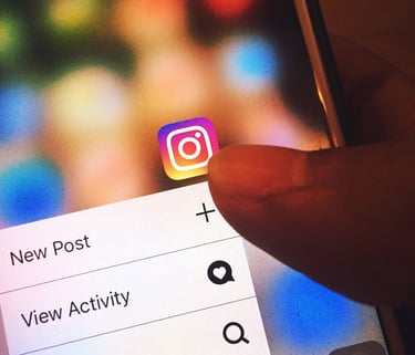 Hand selecting a new Instagram post to follow Auckland International Film Club on social media.