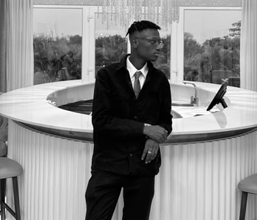 reed in a suit and tie standing in front of a bar