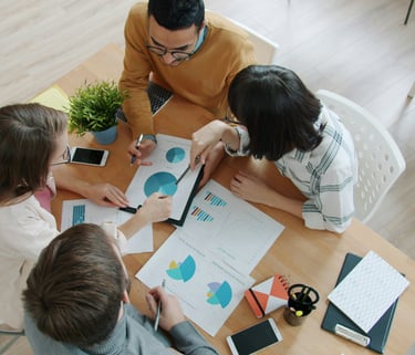 equipo de trabajo revisando y comentando gráficos y diagramas