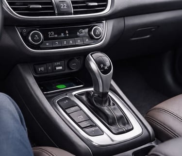 Interior de carro automático com foco no câmbio e console central em acabamento moderno.