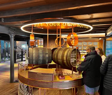 a man and woman standing in front of a barrel of whisky
