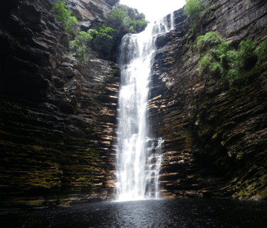 a waterfall in a canyon with a waterfall in the background in Chapada Diamantina