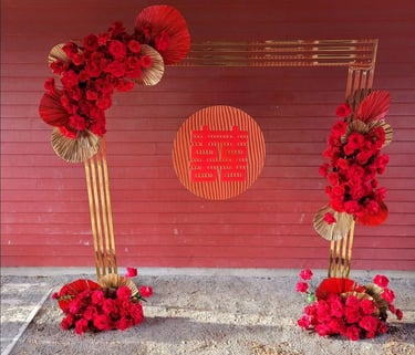 Double happiness signage with a gold chrome backdrop and red roses