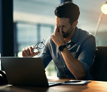 Ein Mann im Büro der zu viel Stress spürt