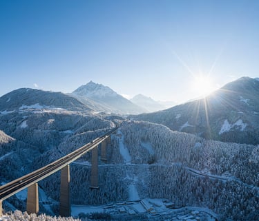 a train traveling over a bridge over a mountain