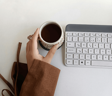 Mesa de trabalho com teclado e xícara de café, energia limpa e o foco mental  pelo café premium
