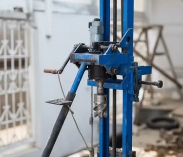 Industrial blue portable core drilling machine used for soil sampling and geotechnical exploration.