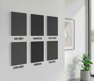 Six textured grey fabric color swatches labeled on a white wall in a modern room.