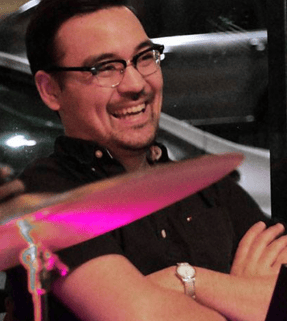 Smiling keyboardist Shawn Schlogel on a musical set