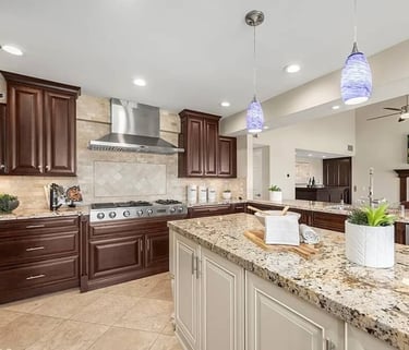 Kitchen remodel with wood cabinets, granite countertops, and pendant lighting.