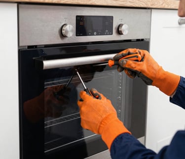 Technician fixing a refrigerator with tools in a bright, clean kitchen.