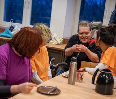 Eine Gruppe von Menschen mit und ohne Behinderungen unterhalten sich angeregt