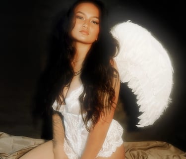 Amelia in a white lace top with angel wings