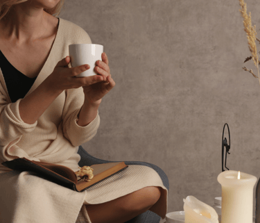 a woman sitting on a chair holding a cup of coffee