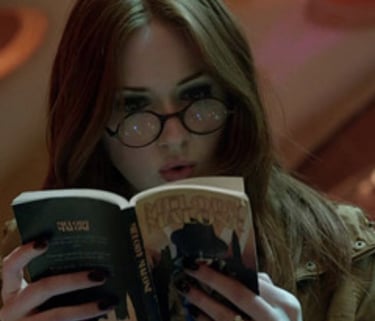 foto da personagem amy pond da serie doctor who lendo um livro dentro da tardis