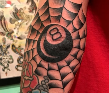 Tattoo of a black 8 ball in the middle of a spider web 