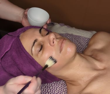 woman getting facial mask applied to skin