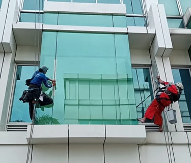 two people are cleaning windows in a building