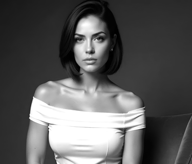 Vivienne Vale seated in a black-and-white portrait, wearing an off-shoulder dress with poised grace.