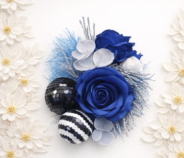 Elegant blue roses and sequined ornaments arranged on a white floral background.
