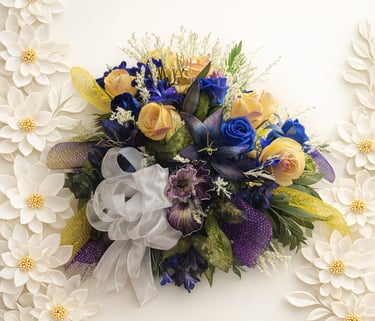 Elegant spray featuring blue and yellow roses with a white ribbon 