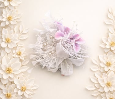 Elegant wrist corsage with purple orchids and pearls surrounded by white paper flowers.