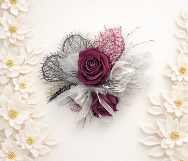 Elegant red rose corsage with silver ribbons and lace on a white background with floral borders.