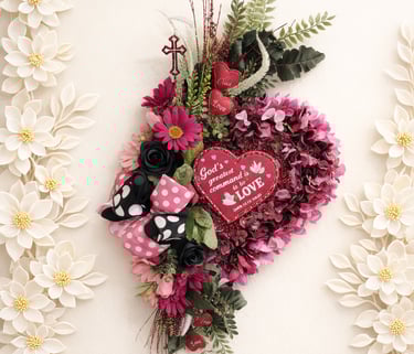 Heart-shaped floral wreath with pink flowers, a religious cross, and a 'God is Love' inspirational message.