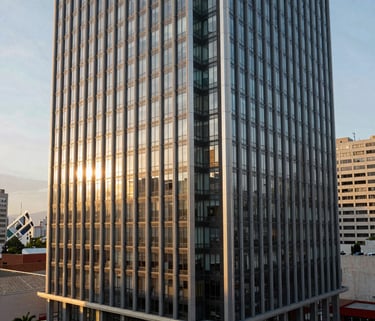A panoramic shot of a modern building facade with glass and steel, located in a thriving Latin American business district, morning sun.