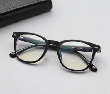 A close-up of stylish budget-friendly eyeglasses resting on a wooden table with soft natural light.