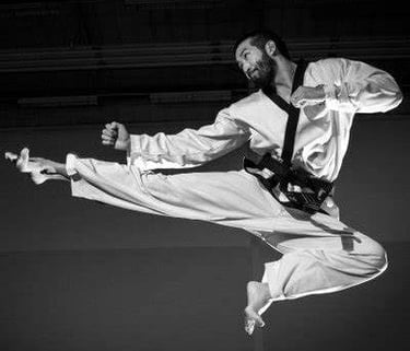 man performing a flying taekwondo kick