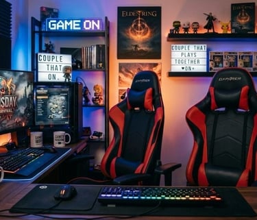 Modern dual-desk gaming setup for couples featuring red and black racing chairs and RGB lighting.