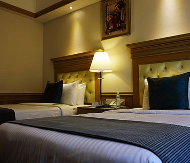 a hotel room with two beds and a lamp. Revenue Management for Hotels with Tímea Pokol Consultant