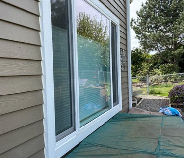 Exterior view of a house showing large sliding glass doors and siding.