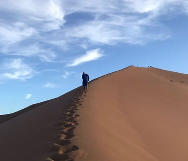 A solitary figure climbs the dune at Erg Zahar