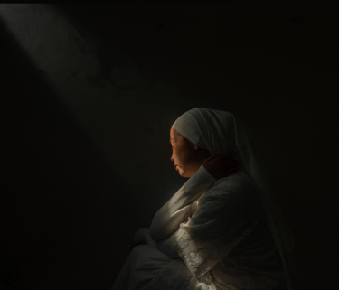 Mulher triste pensando nos problemas da vida, sem perceber a luz do céu sobre ela.