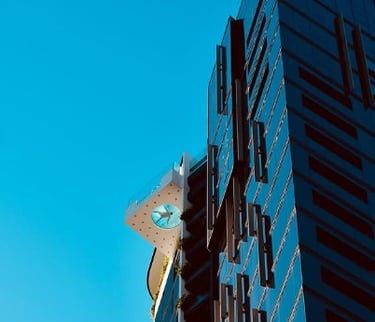 Modern building facade with geometric architectural details against a clear blue sky