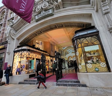 a woman walking down a sidewalk in front of a heritage building