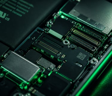 Close-up of a smartphone internal circuit board and lithium-ion battery with green lighting.