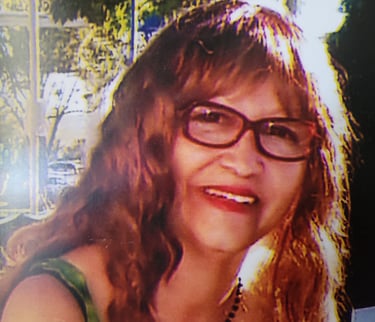 Woman with glasses smiling.