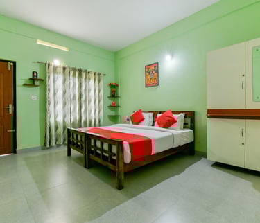Interior view of a luxurious suite at Karapuzha Resorts, showcasing a comfortable king-sized bed, el