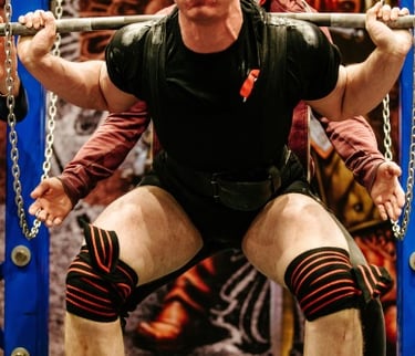a man in a black shirt and knee pads on a bench