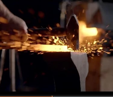a person is using a hammer on g a piece of metal