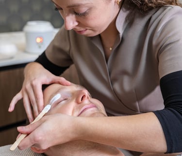 a man getting his eyebrows waxed at a salon